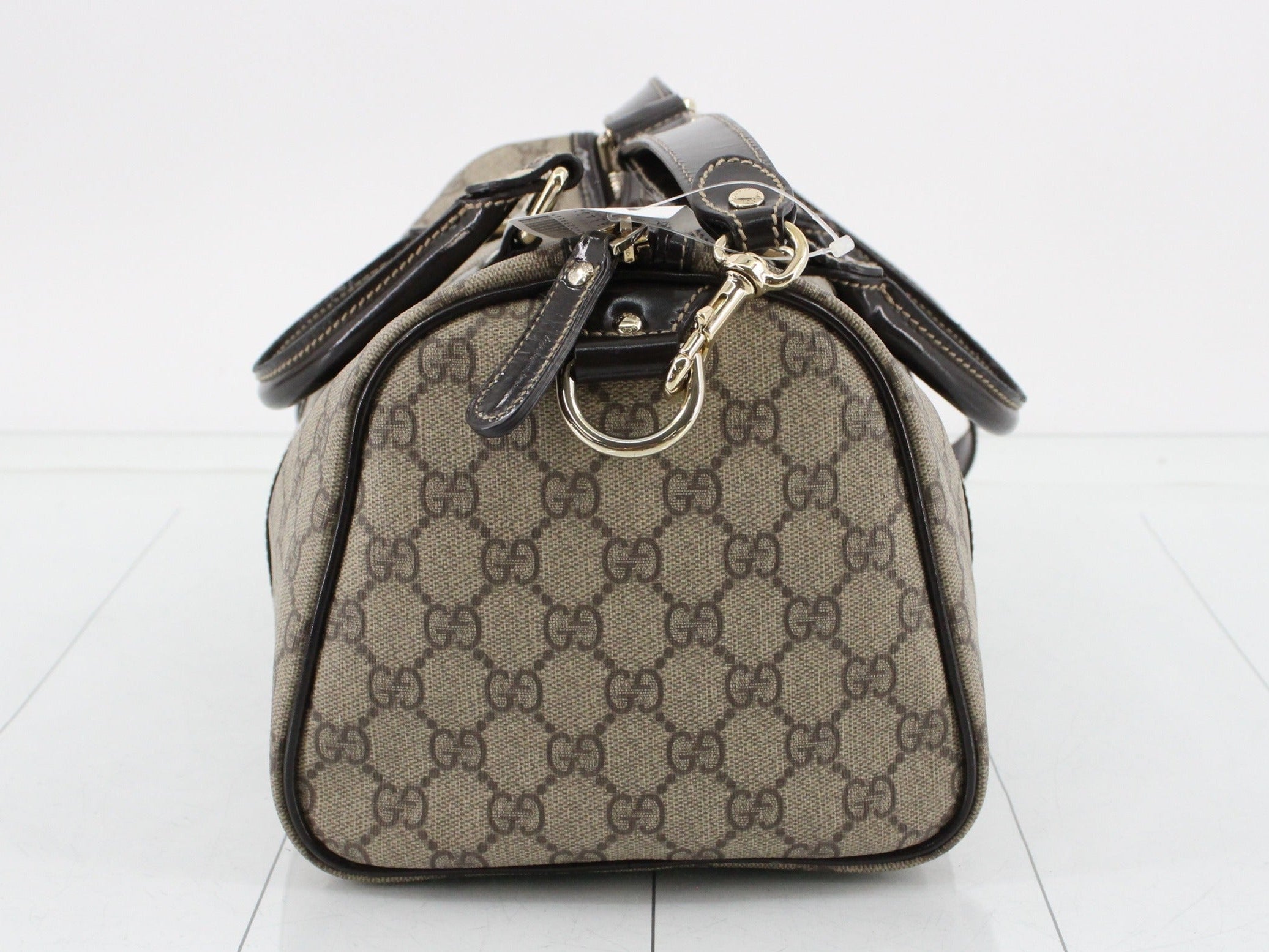 Brown Gucci handbag with gold hardware on a white background