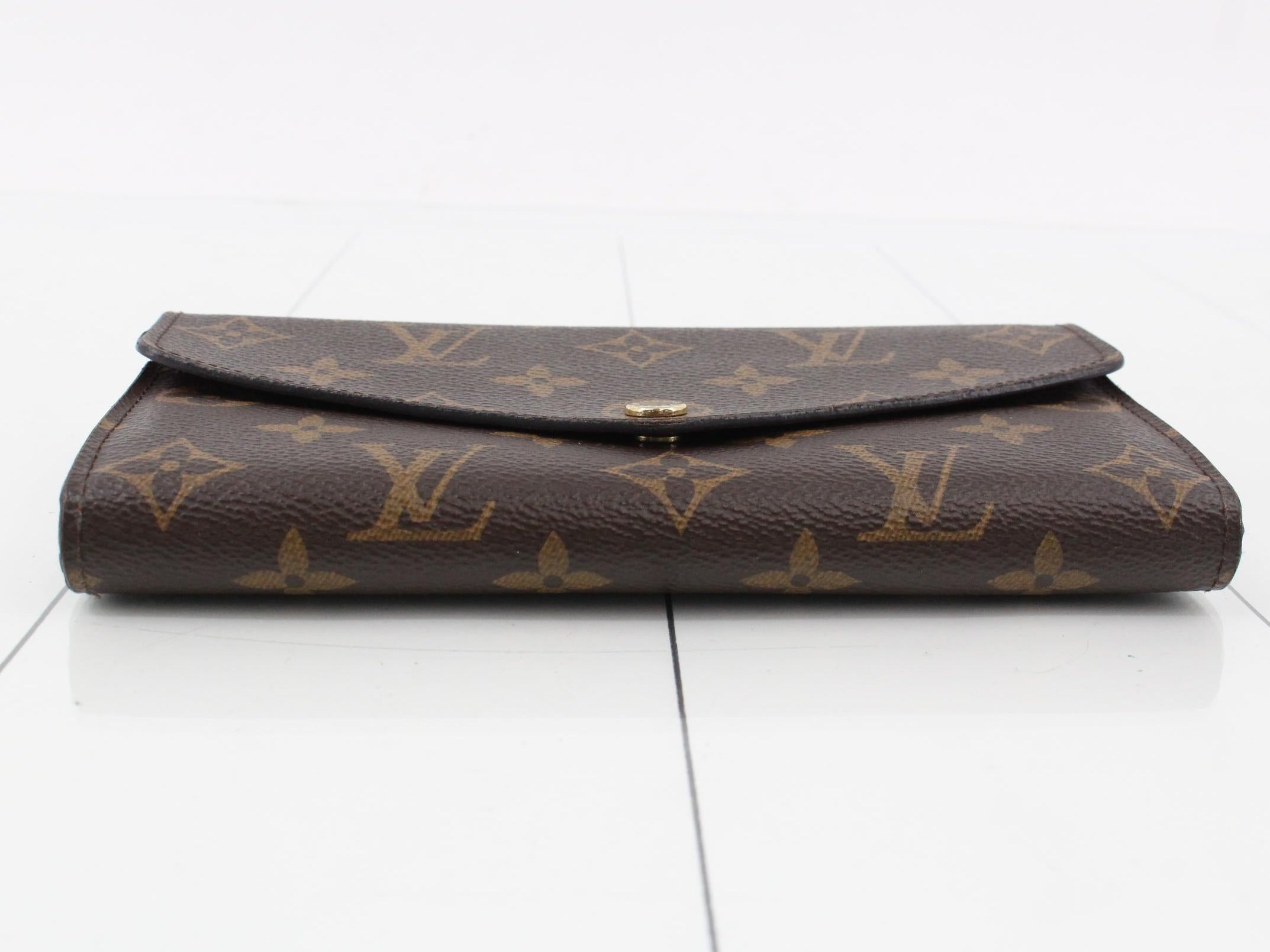 Louis Vuitton wallet with monogram pattern on a white background