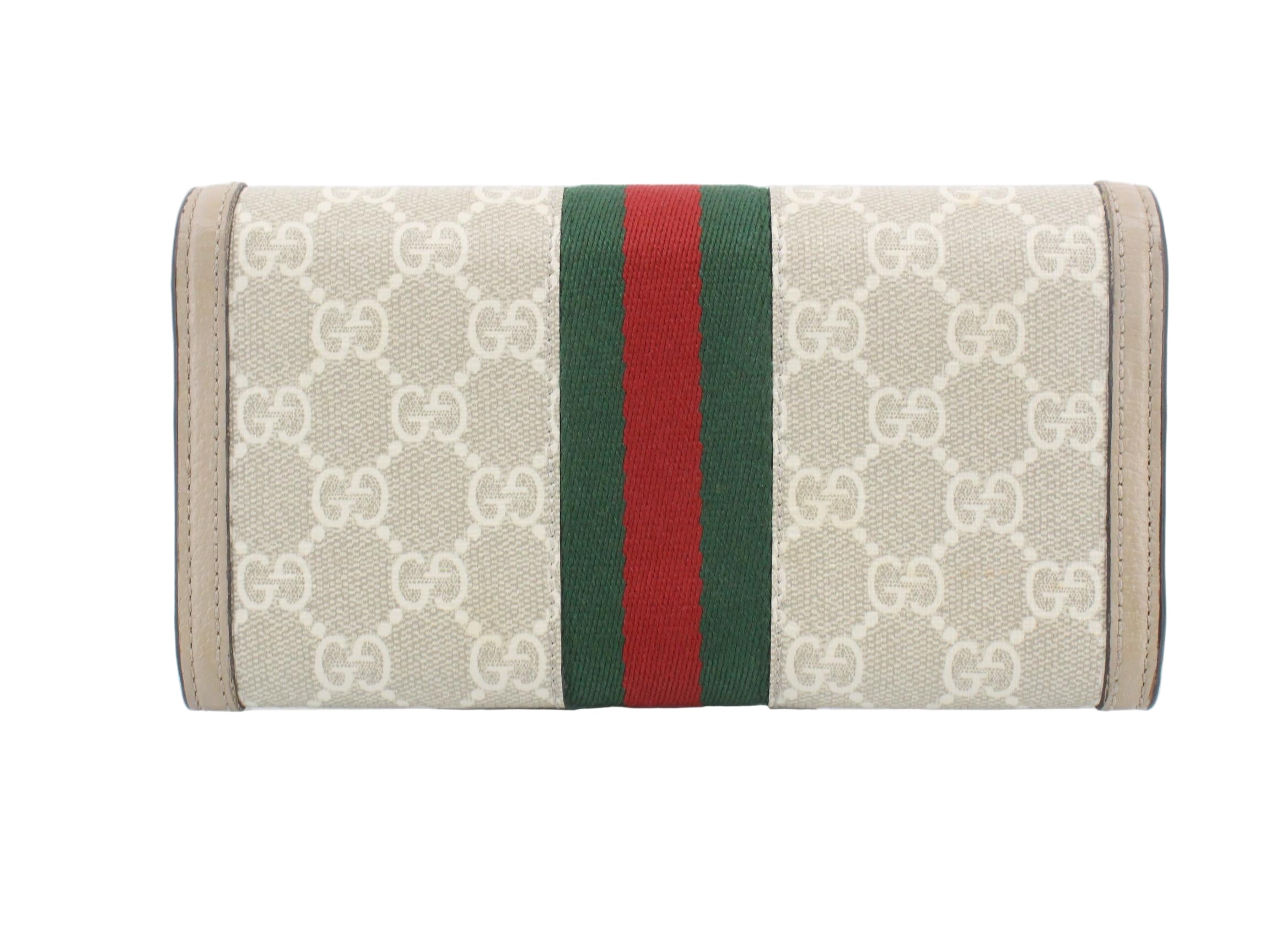Gucci wallet with monogram pattern and red and green stripes on a white background