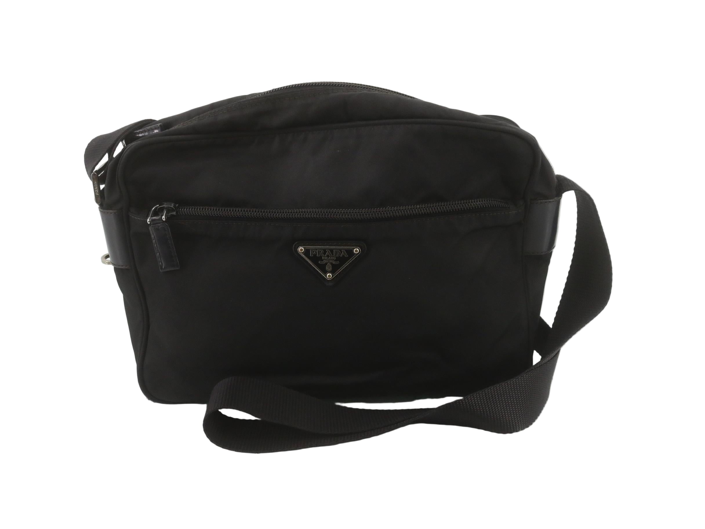 Black nylon Prada bag on a white wooden floor