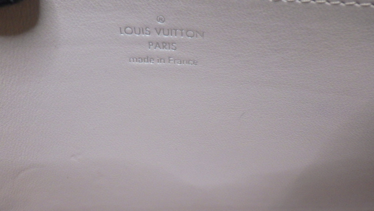 Louis Vuitton logo on a beige leather surface