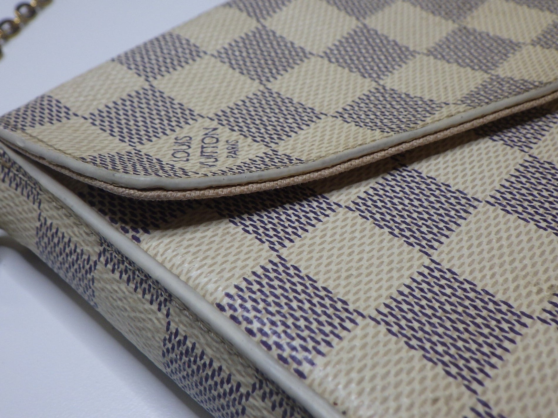 Louis Vuitton handbag with checkered pattern on a white background