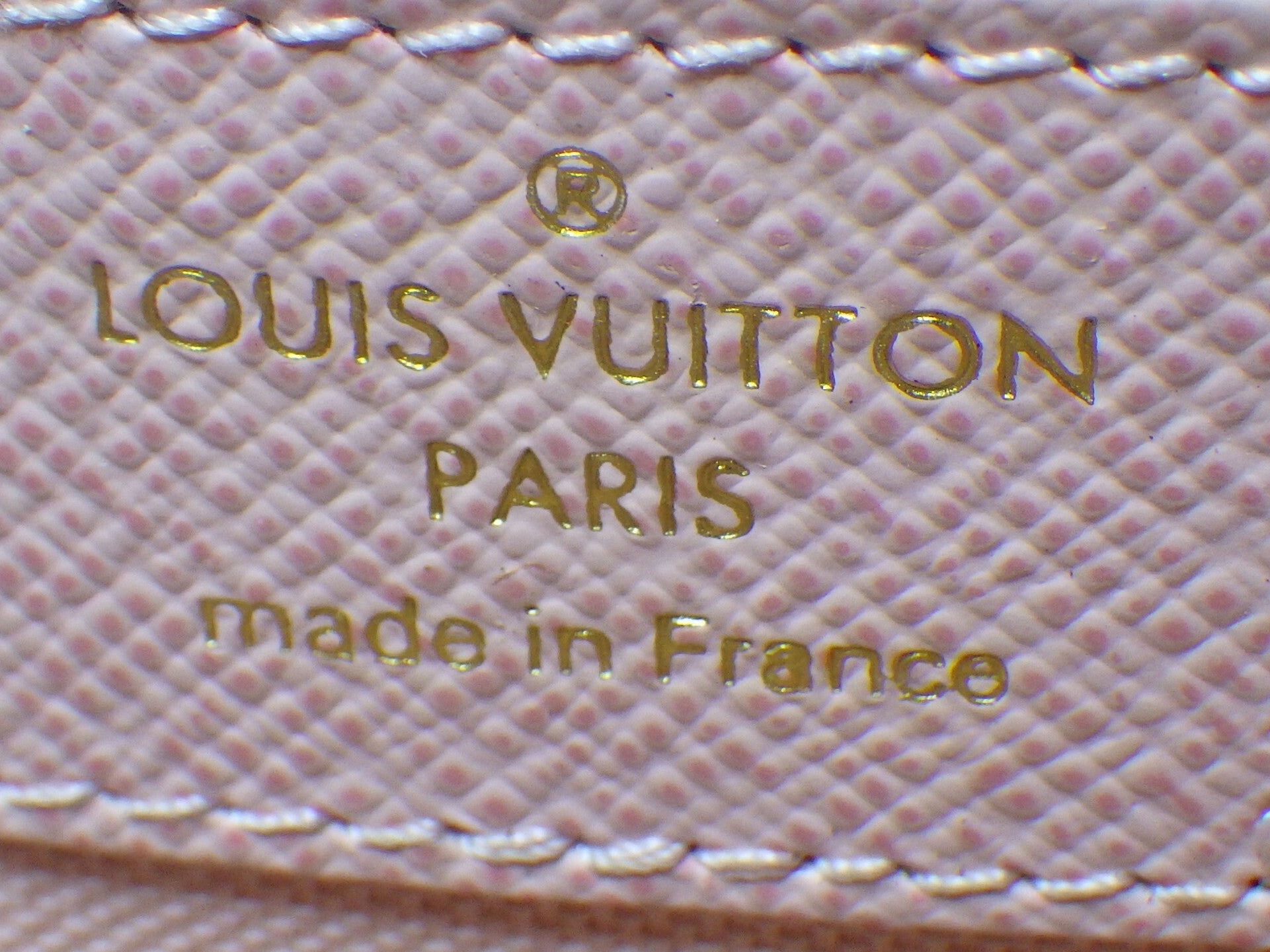 Louis Vuitton logo and text on a textured surface