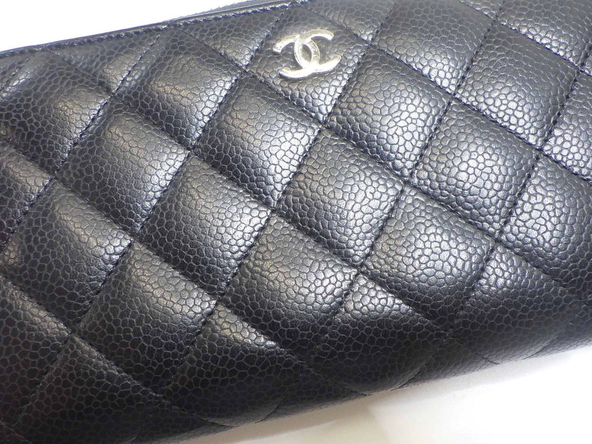 Black quilted leather wallet with gold CC logo on a white background