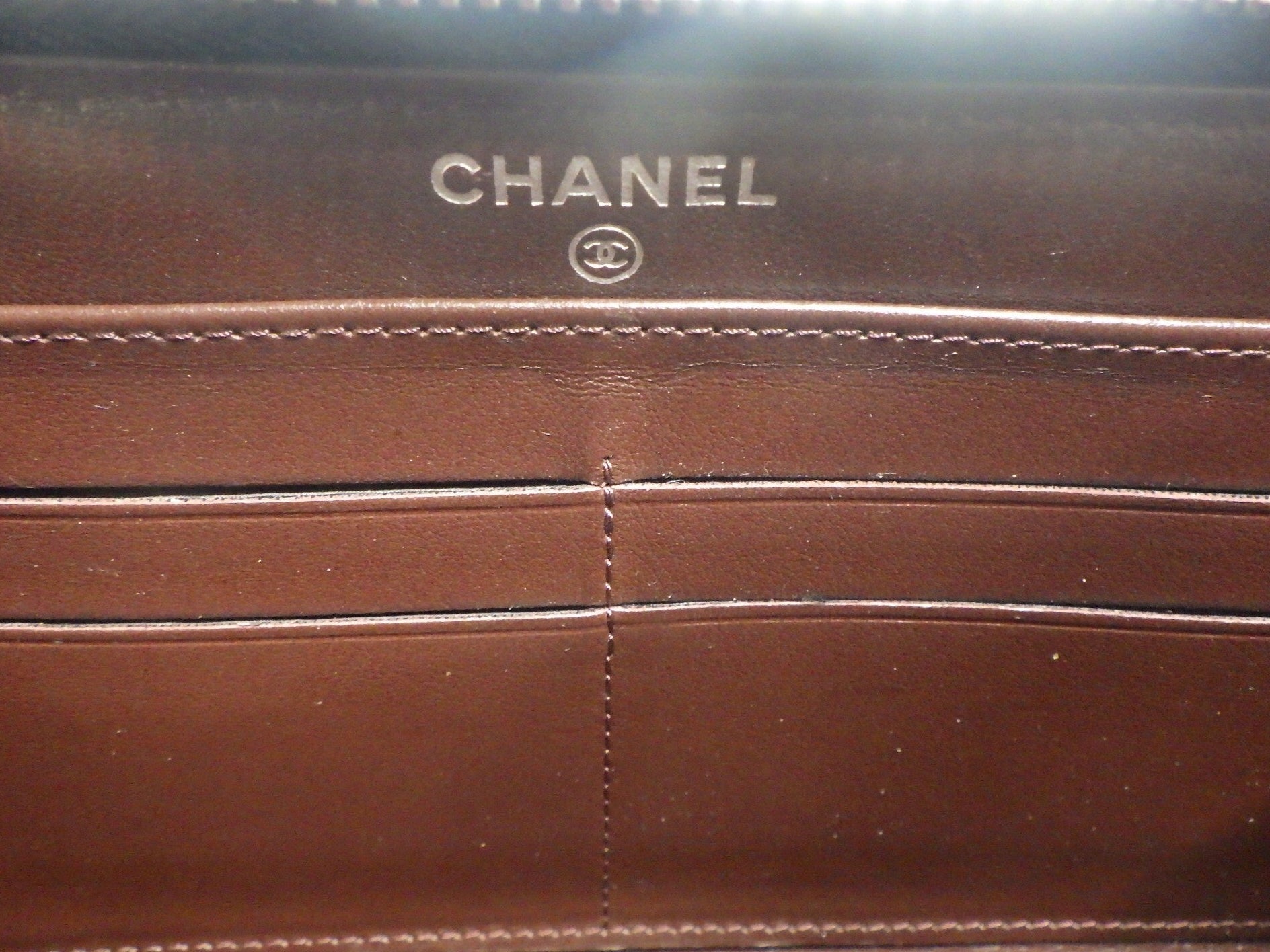 Close-up of a brown Chanel wallet with visible branding.