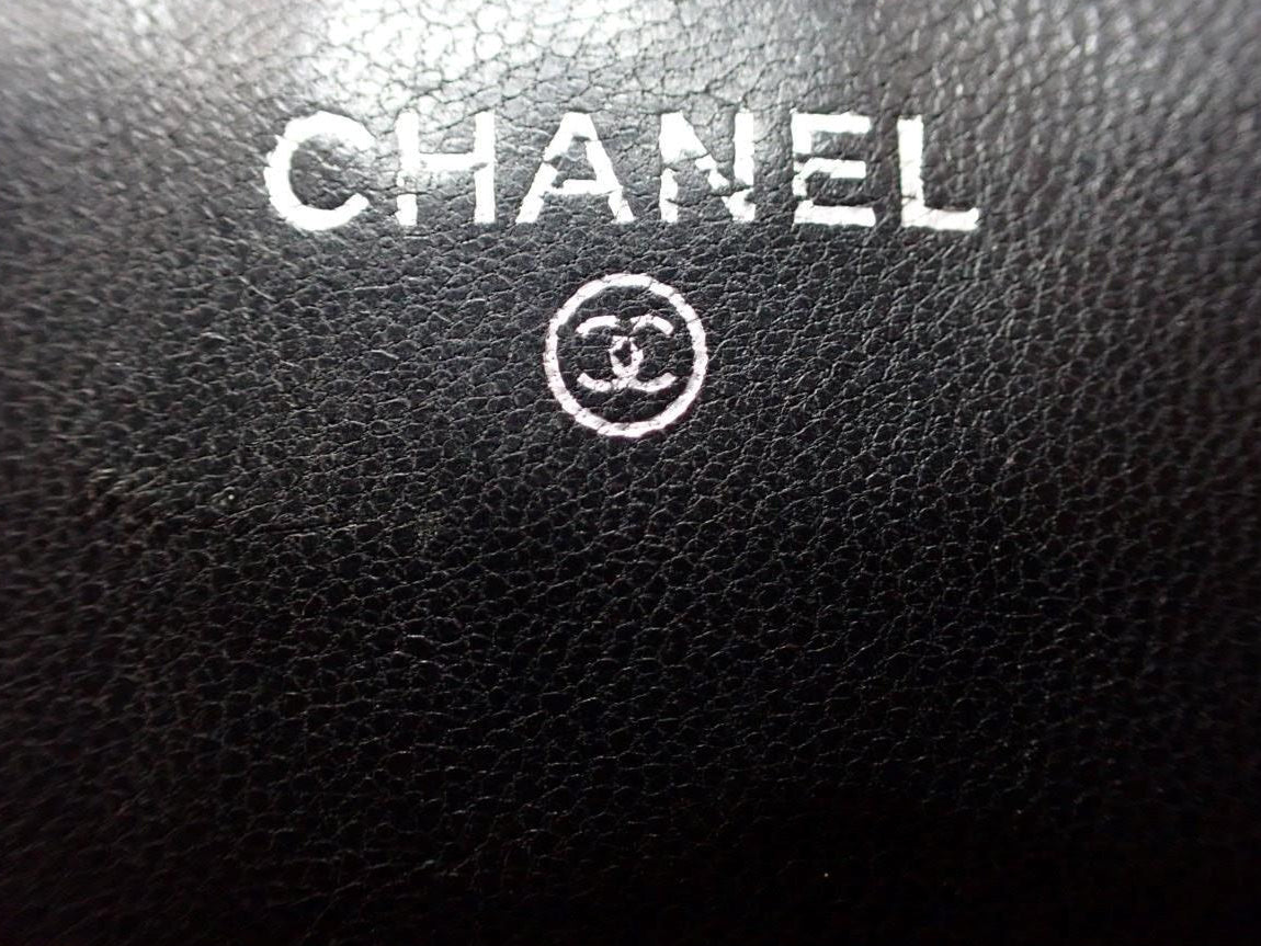 Close-up of Chanel logo on black leather surface
