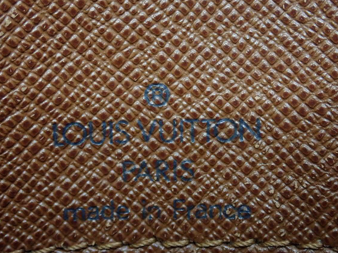 Louis Vuitton logo and text on a textured brown background