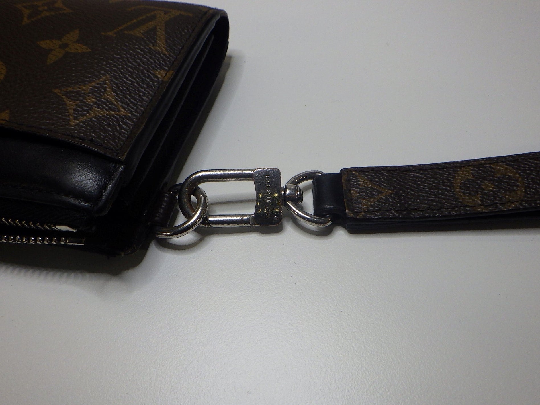 Louis Vuitton wallet with monogram strap on a white background